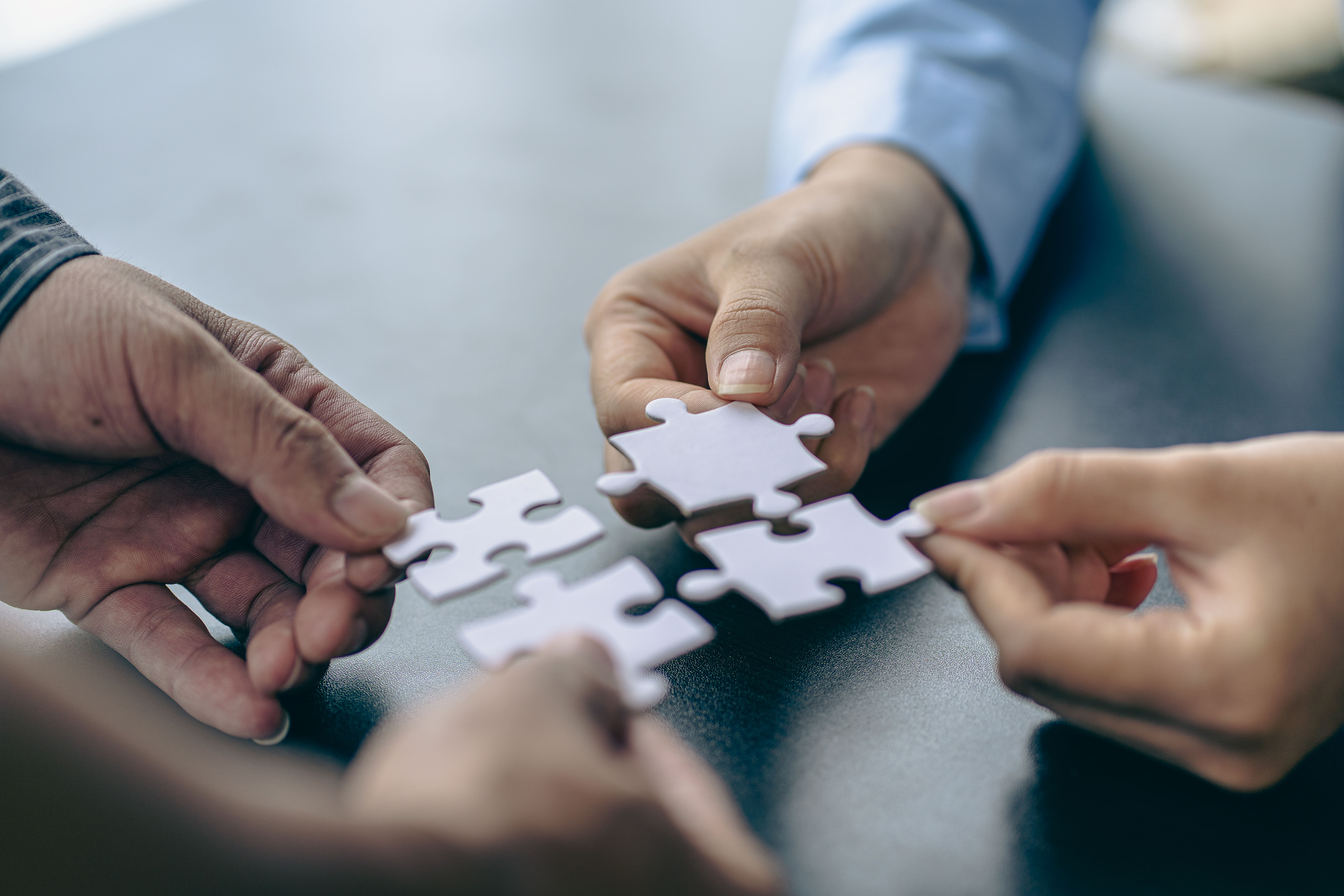 People holds in hand a jigsaw puzzle. Business solutions, success and strategy.Group of business people assembling jigsaw puzzle